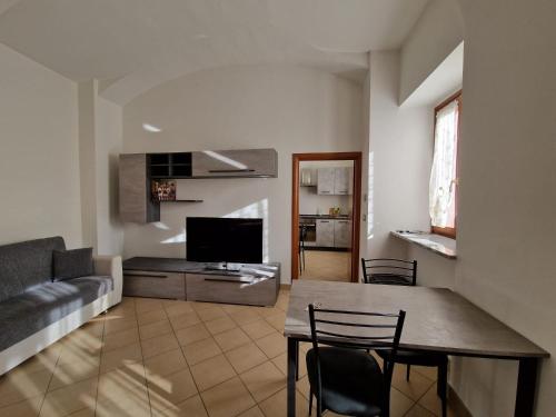 ein Wohnzimmer mit einem Tisch und einem Sofa in der Unterkunft Il Fiocco Dla Duja di Ciriè in Ciriè