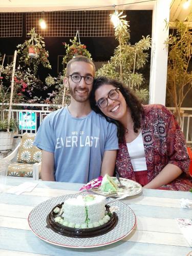 a man and a woman sitting at a table with a cake at INNI Homestay in Malang