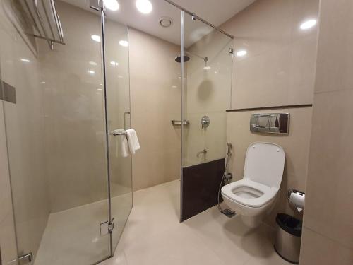 La salle de bains est pourvue d'une cabine de douche et de toilettes. dans l'établissement Brilliant Hotel & Convention Centre, à Indore