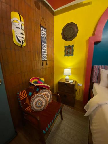 a room with a chair and a yellow wall at Rain Airport Bed and Breakfast in Manila