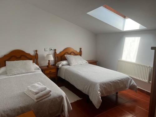 a bedroom with two beds and a skylight at Camín de la reina in San Juan de Parres