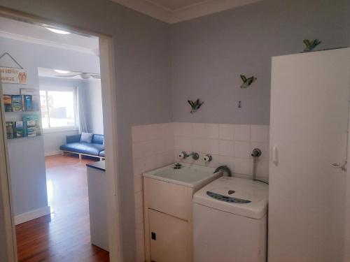a small kitchen with a sink and a refrigerator at Watts @ Callala Beach-Pet Friendly in Callala Beach