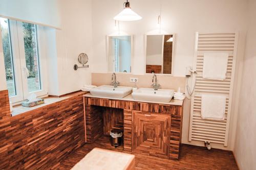 a bathroom with two sinks and a large mirror at Landhotel Kahltalmühle in Alzenau