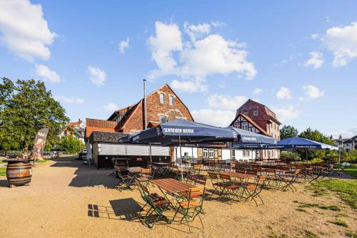 a group of chairs and umbrellas in front of a building at Landhotel Kahltalmühle in Alzenau in Unterfranken