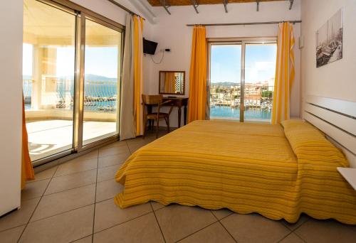 a bedroom with a large bed and a large window at Chez Cocò - Murphy Holiday Home in La Maddalena