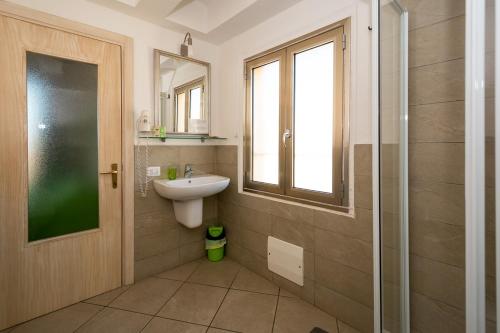a bathroom with a sink and a glass shower at Chez Cocò - Murphy Holiday Home in La Maddalena
