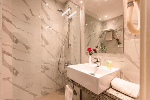 فندق الليوان في عمّان: حمام أبيض مع دش ومغسلة
