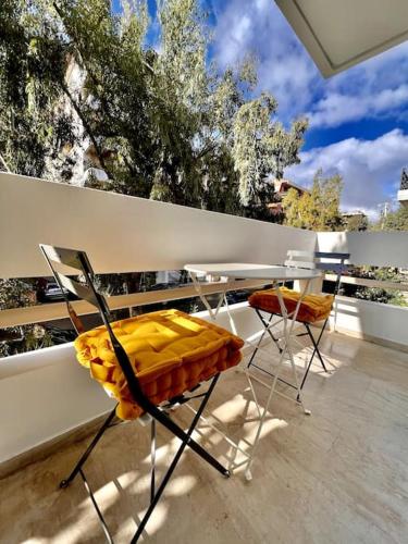 a balcony with a table and chairs and trees at Coastal Studio in Palaio Faliro in Palaión Fáliron