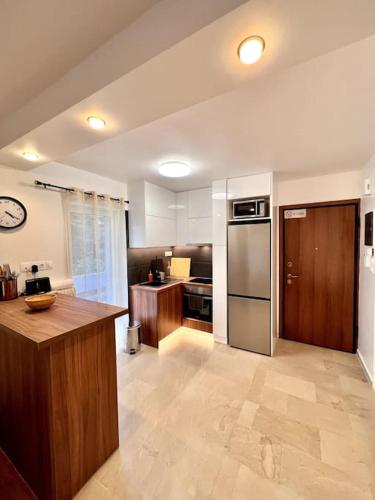 a kitchen with wooden cabinets and a stainless steel refrigerator at Coastal Studio in Palaio Faliro in Palaión Fáliron
