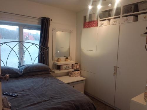 1 dormitorio con cama, espejo y ventana en Albany Rooms en Bexley