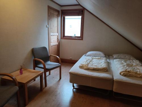 a bedroom with a bed and a chair and a window at Fossanmoen in Forsand