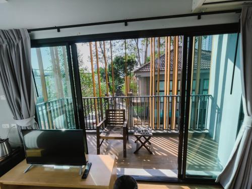 a living room with a sliding glass door to a balcony at Nest by Sangob in Bangkok