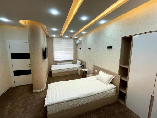 a bedroom with two beds and a window in it at Chinor Hotel Fergana in Fergana