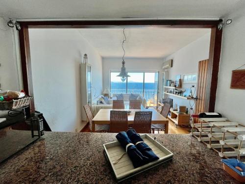 un soggiorno con tavolo e una sala da pranzo con vista sull'oceano di Apartamento con playa y vistas en la Costa Brava a Begur