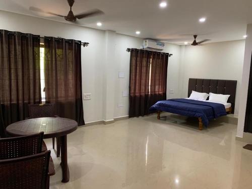 a bedroom with a bed and a table and a table sidx sidx sidx at Vishram Homestay, Malpe Beach, Udupi in Malpe