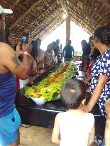 a group of people standing around a buffet with food at Dolphin Village in Kalpitiya