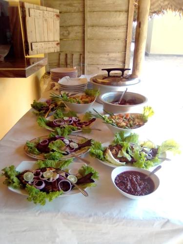 a table with many plates of food on it at Dolphin Village in Kalpitiya