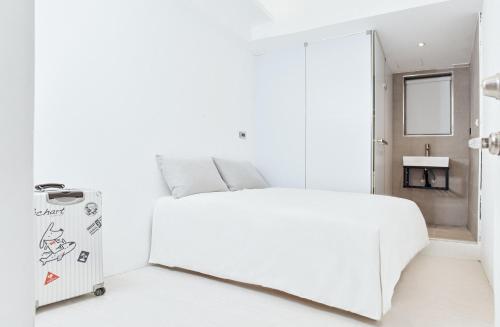 a white bedroom with a white bed and a mirror at White Space Design Hotel in Taipei