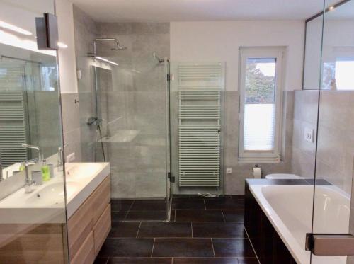 a bathroom with a tub and a sink and a shower at Ferienwohnung Urlaubsfreude für 2 bis 7 Personen in Paternion