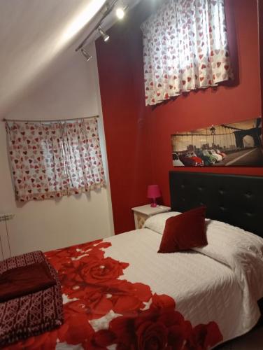 a bedroom with red walls and a bed with red flowers at Le mansarde di Via Isonzo in Chieti