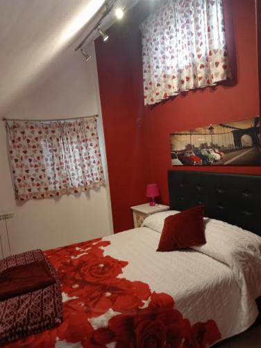 een slaapkamer met rode muren en een bed met rode bloemen bij Le mansarde di Via Isonzo in Chieti
