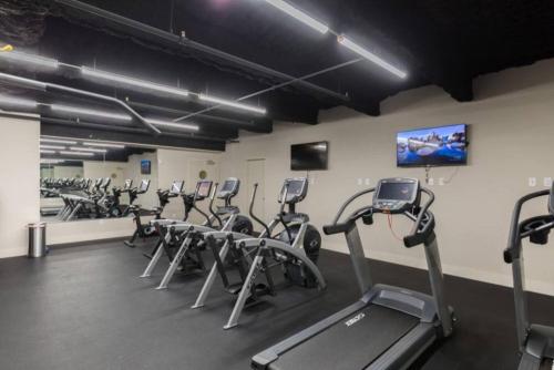 a gym with rows of exercise bikes and a flat screen tv at Tasteful Condo Walking Distance to French Quarter in New Orleans