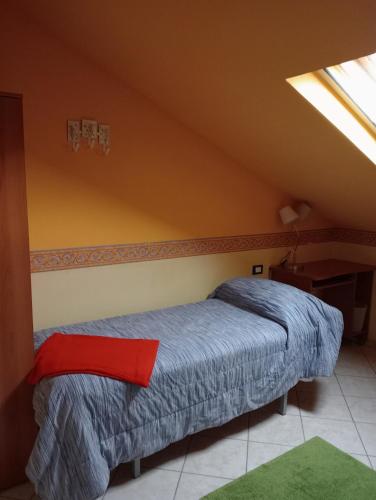a bedroom with a bed with a red pillow on it at Le mansarde di Via Isonzo in Chieti