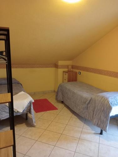 a bedroom with two beds and a red rug at Le mansarde di Via Isonzo in Chieti