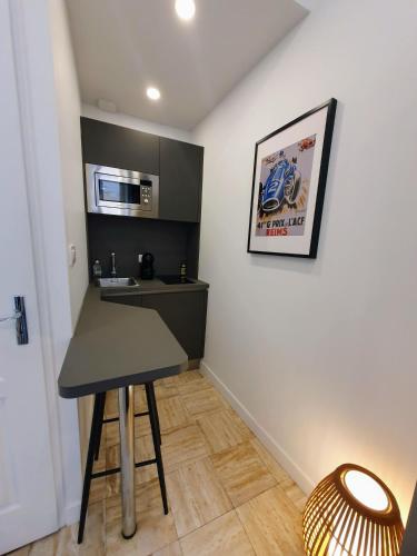 a small kitchen with a table and a microwave at Appartement Premium dans une belle demeure - Hyper centre-ville de Reims in Reims