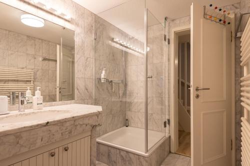 La salle de bains est pourvue d'une douche, d'un lavabo et d'un miroir. dans l'établissement Achter Dünem, Whg 4, à Wenningstedt