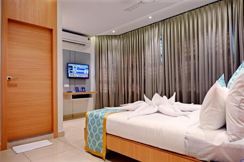 1 dormitorio con 1 cama con almohadas blancas en Hotel Sri Krishna Residency, en Udupi