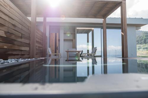 a house with a swimming pool with a table and chairs at Alissachni SeaSide Hotel in Derveni
