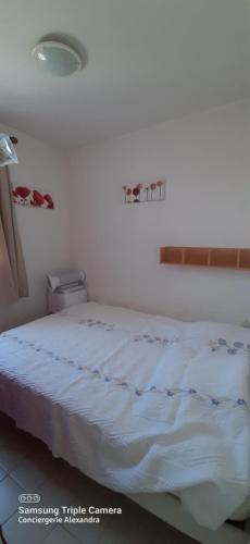 a bedroom with a bed with a white bedspread at Les Capitelles : Appartement vue montagne en residence avec piscine -sur le front de mer in Saint-Cyprien