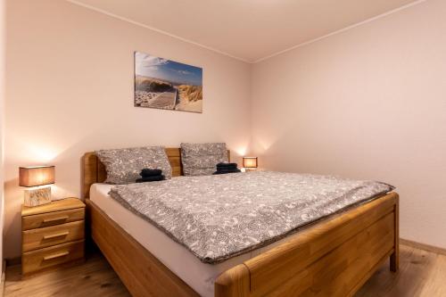 sypialnia z drewnianym łóżkiem i 2 lampami w obiekcie Ferienwohnung Finkwarder w mieście Westerdeichstrich