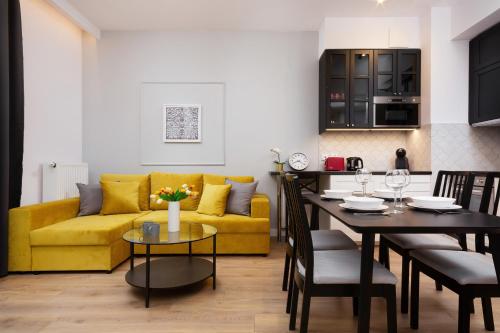 sala de estar con sofá amarillo y mesa en Central Business District Warsaw Apartments by Renters en Varsovia