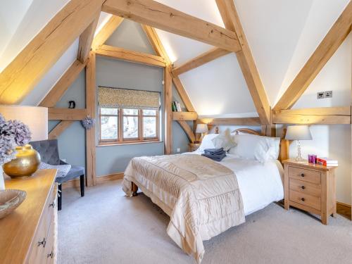 ein Schlafzimmer mit einem großen Bett und einem Fenster in der Unterkunft Chestnut Cottage in Leighton