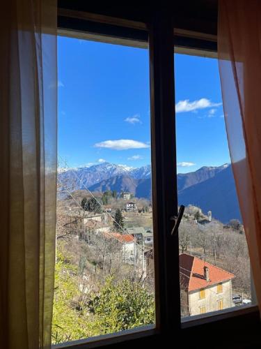 a window with a view of a mountain view at VillaMarinaPigra Lake View Apartments in Pigra