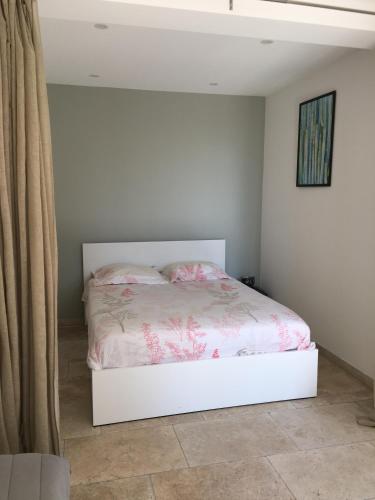 - une chambre avec un lit blanc et des fleurs roses dans l'établissement independent house of 30m2 near creeks, à La Ciotat