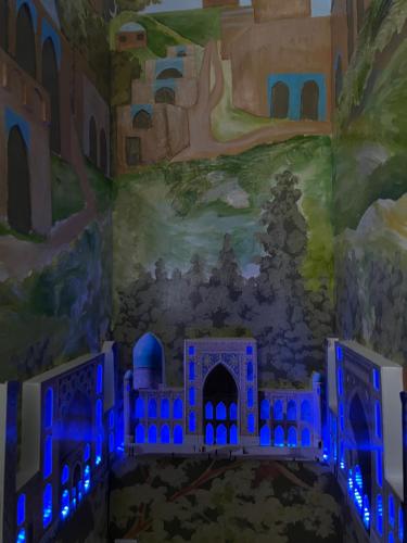 uma pintura de um castelo num quarto com luzes azuis em Qozi Hotel em Samarkand