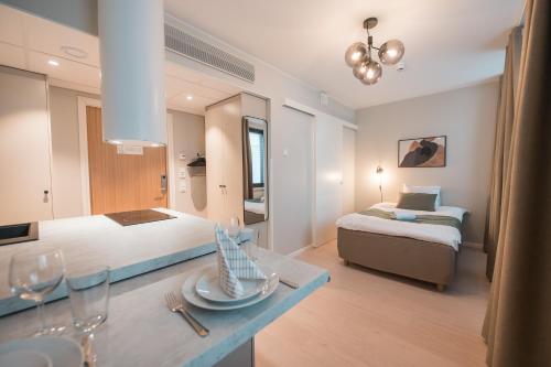 a hotel room with two beds and a table with wine glasses at Forenom Aparthotel Tampere Kauppakatu in Tampere