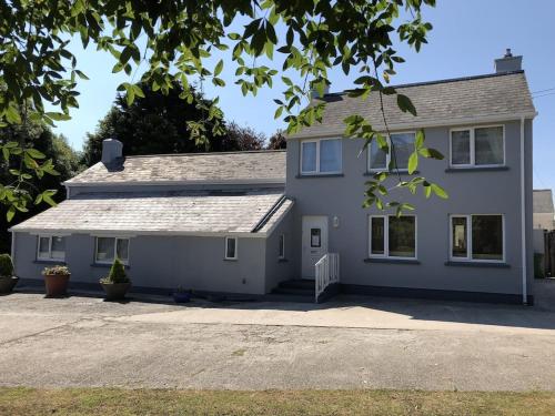 a white house with a driveway in front of it at The Cottage Cox Hill Chacewater in Truro