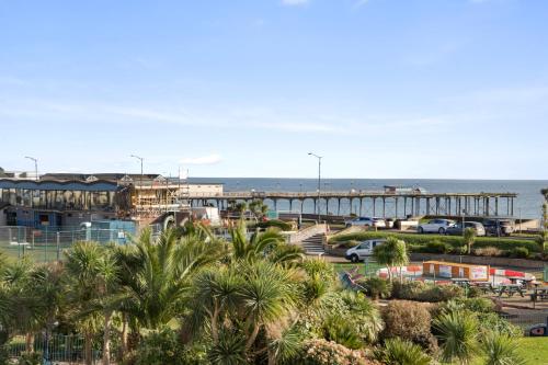 a view of a pier with palm trees and the ocean at Seabreeze in Teignmouth