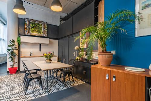 une cuisine avec une table et des chaises et un mur bleu dans l'établissement Mon loft, à Asnières-sur-Seine