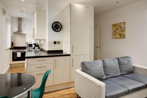 Una sala de estar con un sofá y una cocina. en Charles Hope Swindon, en Swindon
