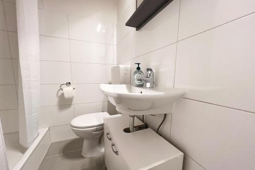 a white bathroom with a toilet and a sink at Cozy apartment with balcony in Leverkusen
