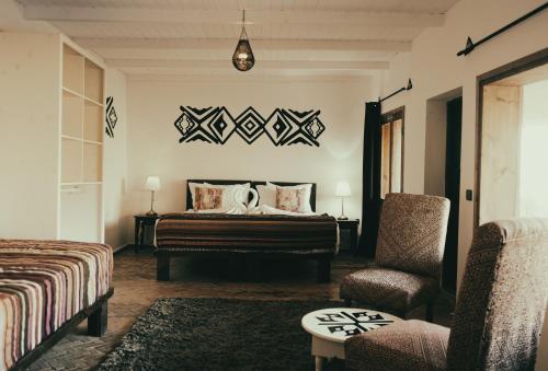 Habitación de hotel con cama y silla en Les Dunes de Dakhla, en Dakhla