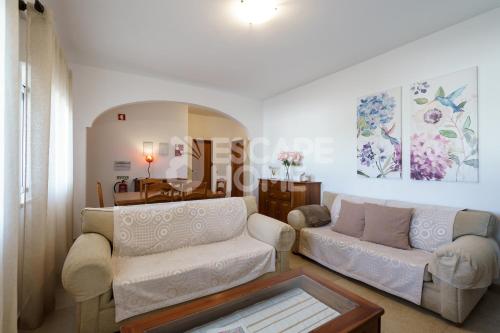 een woonkamer met 2 banken en een tafel bij Villa Sunset Lovers in Alcantarilha
