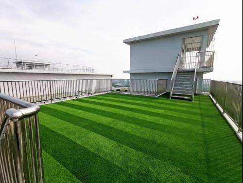 a balcony with green grass on a building at FREE WIFI-FI Travelers HomestySitiawan 5-8pax The Venus Aparment in Seri Manjung
