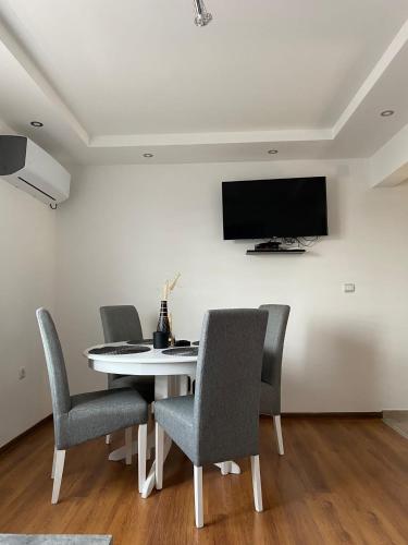 a dining room table with chairs and a tv on a wall at Kuća za odmor CAR - Tekija in Tekija