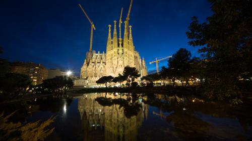 a building with a reflection in the water at night at Catalunya Casas Relax and Recharge - only 34km from Barcelona! in Rubí
